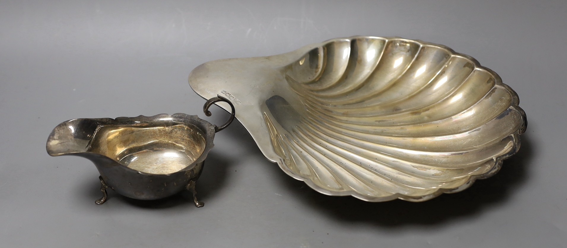 An Edwardian silver shell shaped dish, Atkin Brothers, Sheffield, 1904, 28.1cm and a silver sauceboat, 13.3oz.